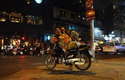 Person reclining on a parked motorbike