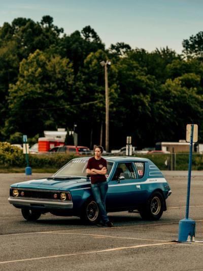 woman standing in front of her race car