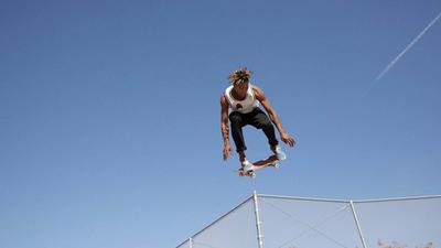 A skateboarder coasts through the air