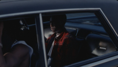 Man sits in the back of a car.
