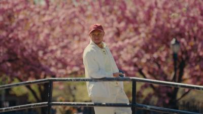 artist Hasani Salehe stands under a tree in a park