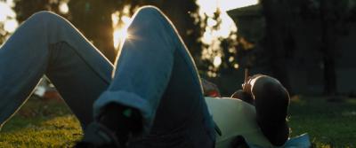 A young person lays in the grass