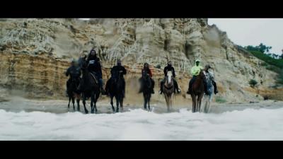 Compton Cowboys ride their horses along the beach