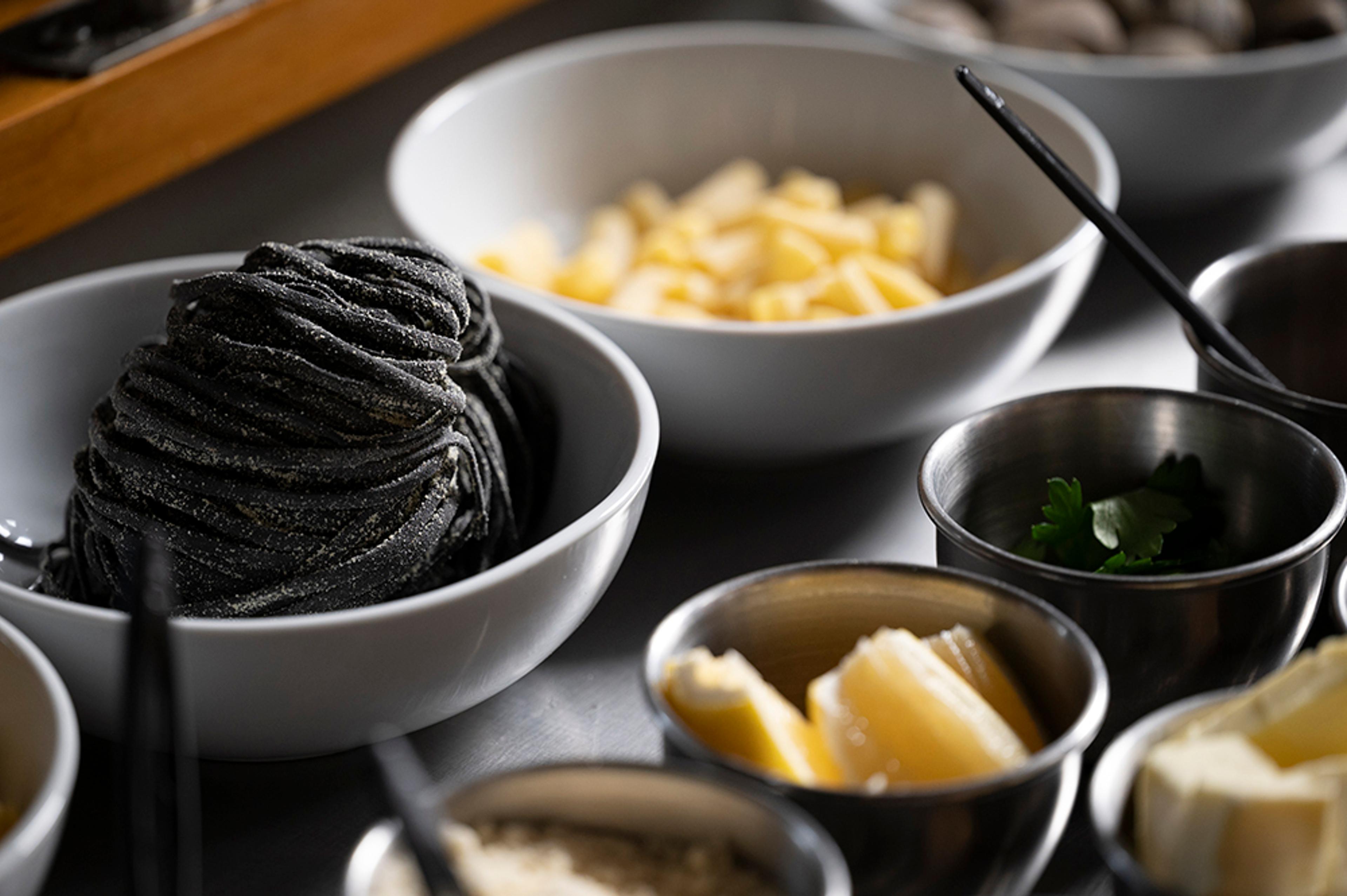 Fresh ingredients including squid ink pasta, butter, parsley, house-made pasta