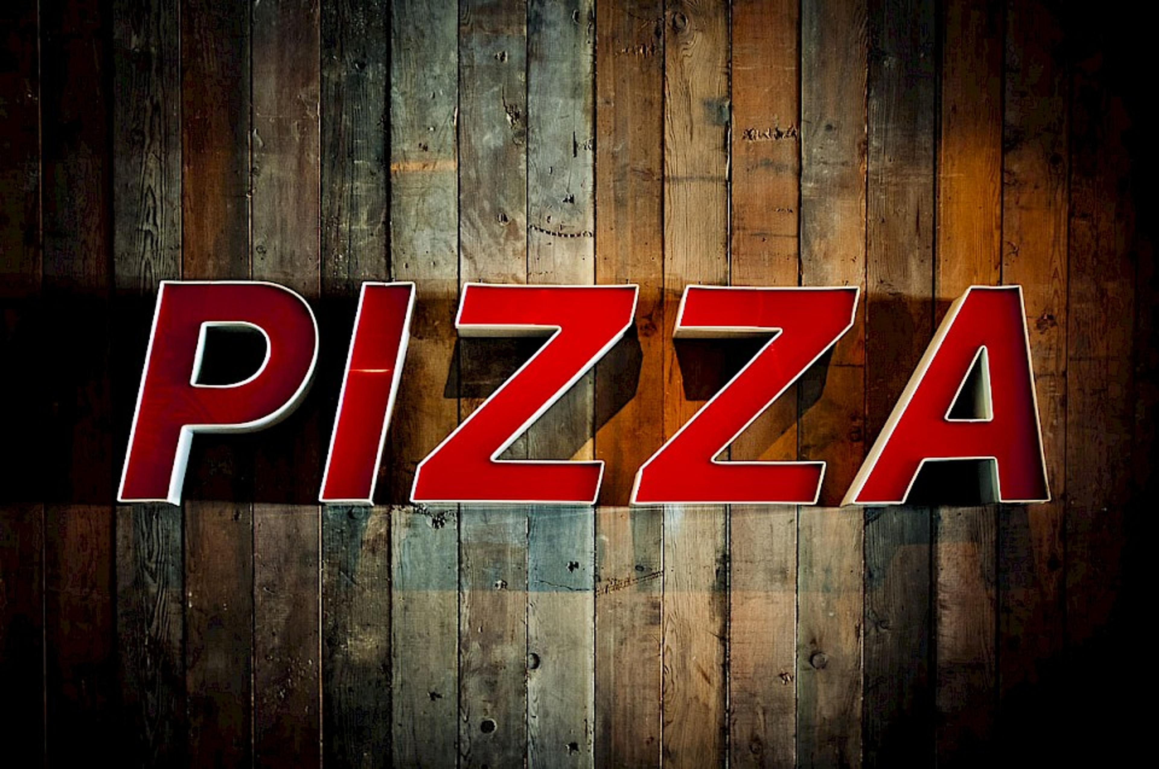 pizza sign on reclaimed wood wall