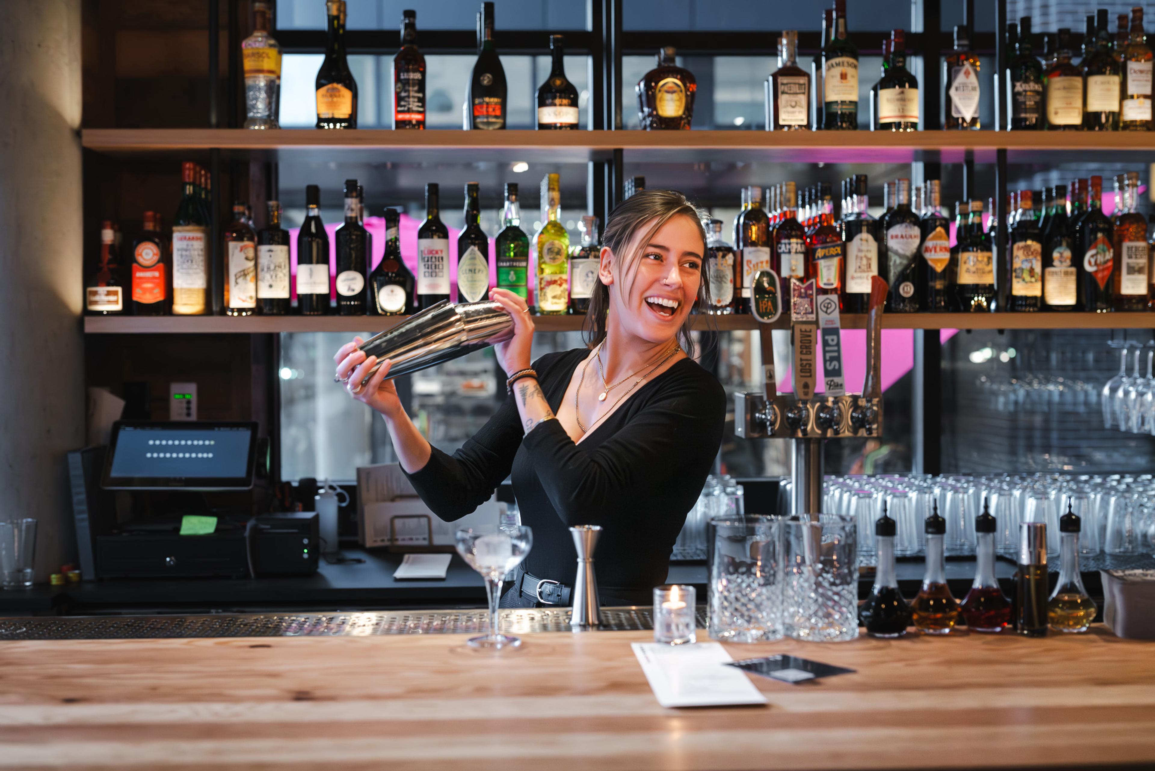 bartender shaking a cocktail behind the bar