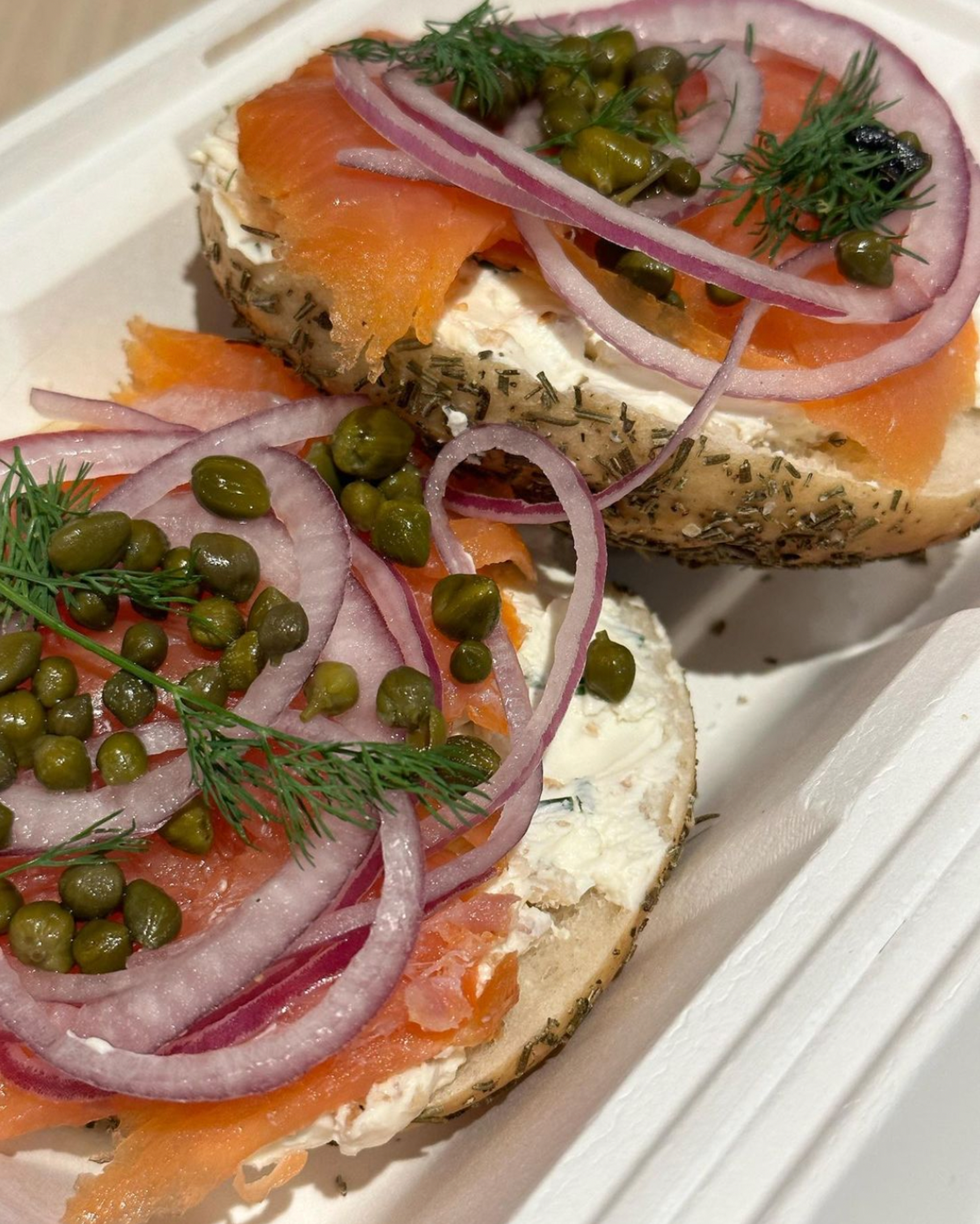 open face lox bagel with schmear, capers, and red onion