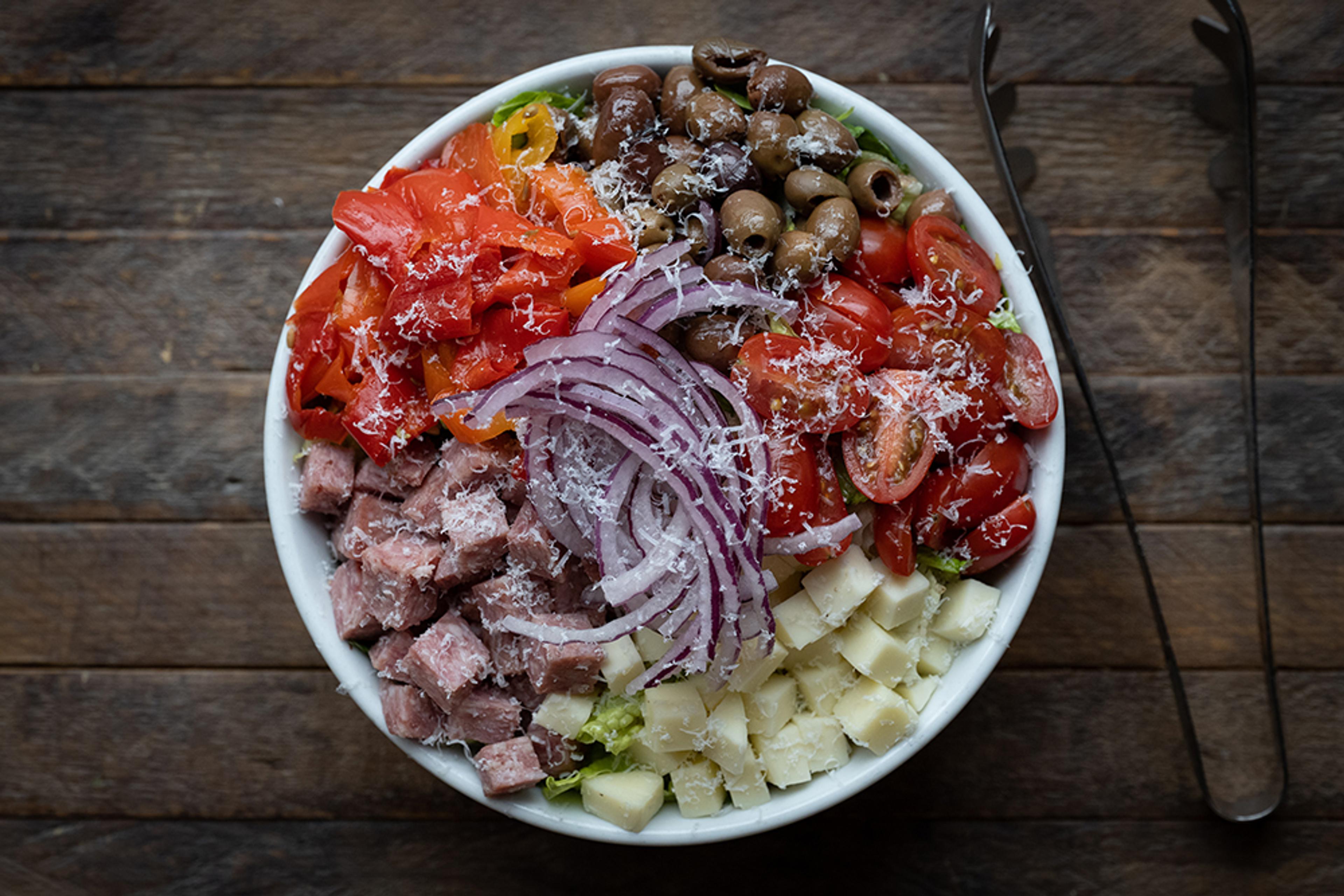 Chop salad with ham, mozzarella, red onion, tomato, sweet peppers, and olives