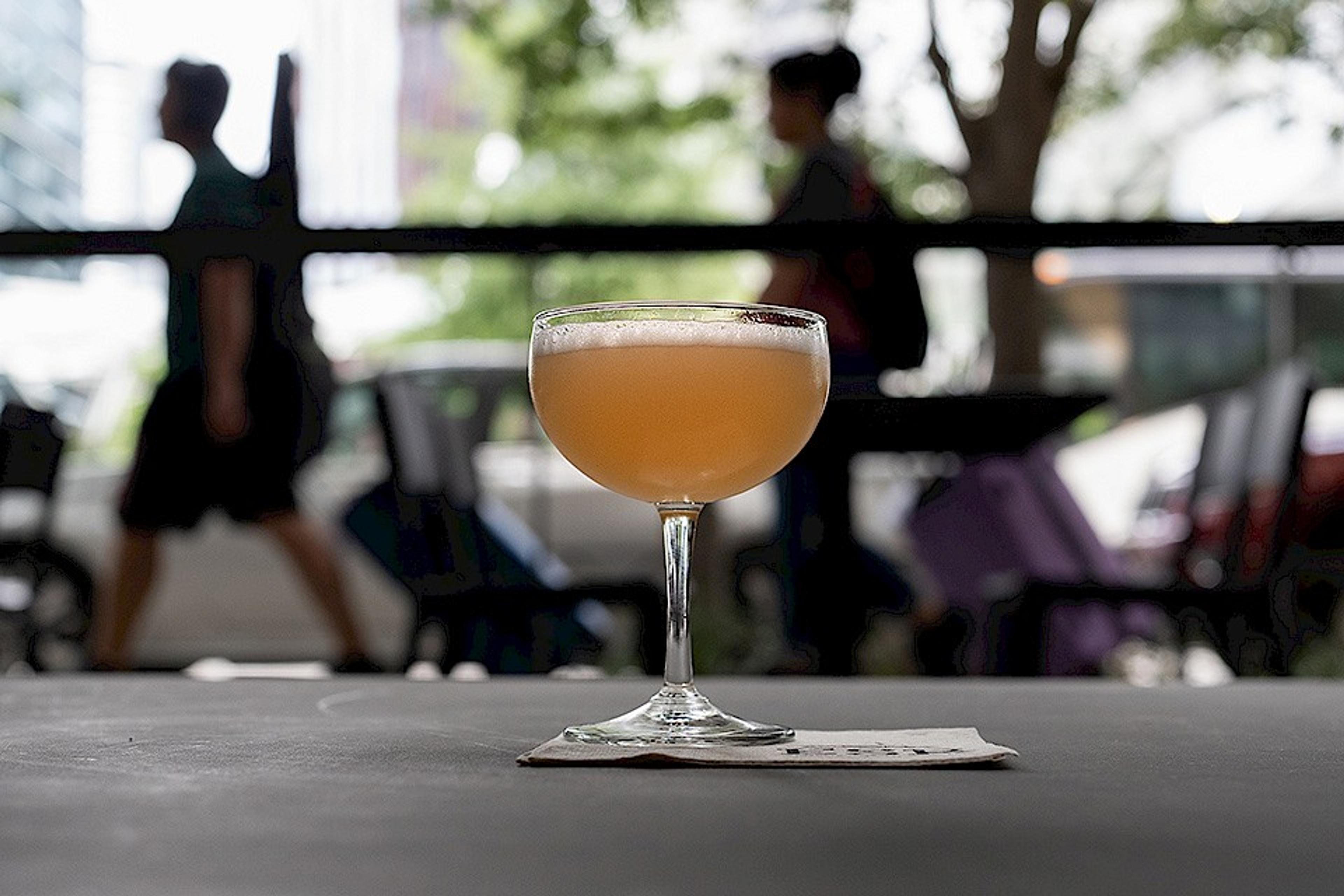 cocktail on patio with pedestrians and the Amazon Spheres in the background