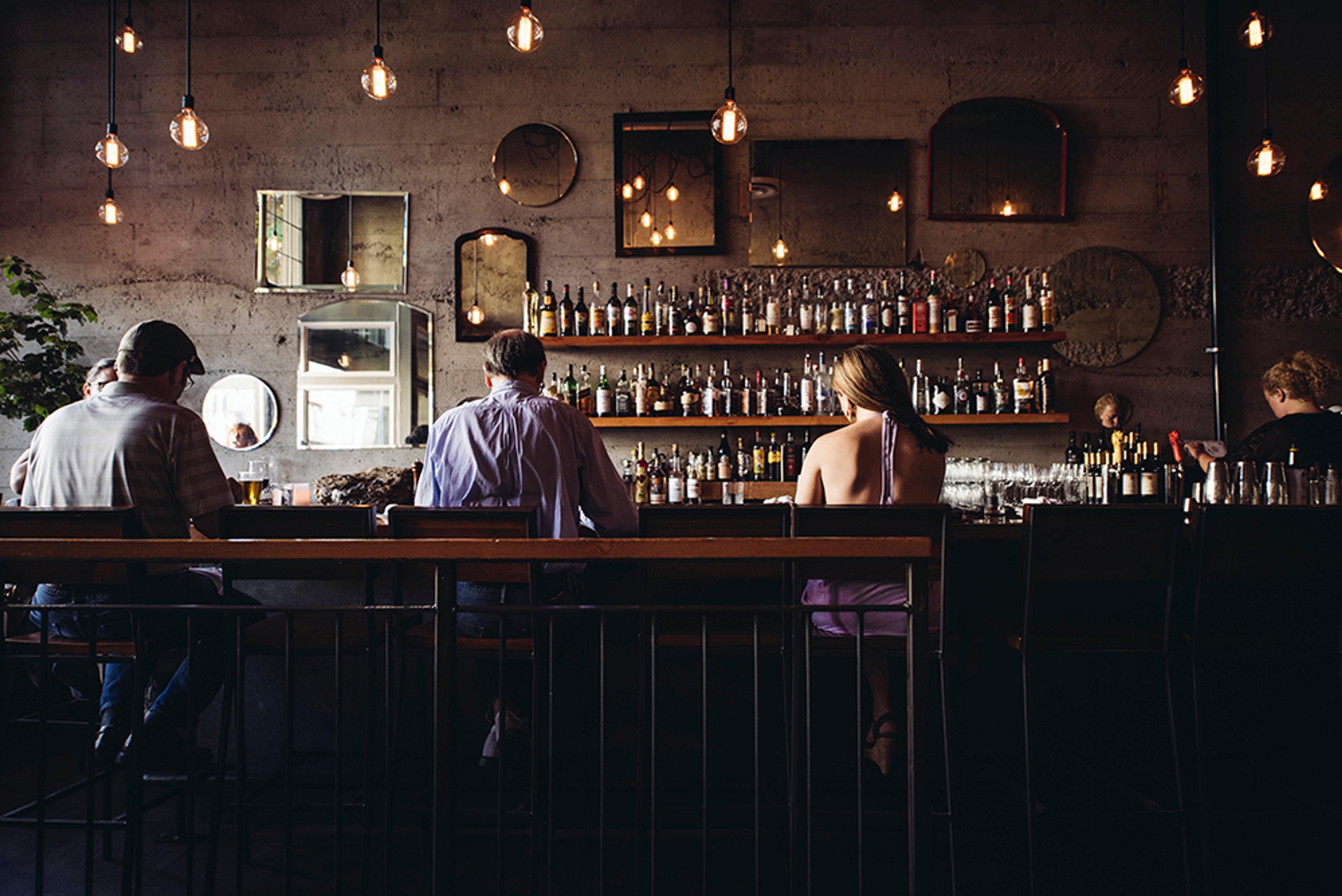 Guests sitting at the bar during happy hour