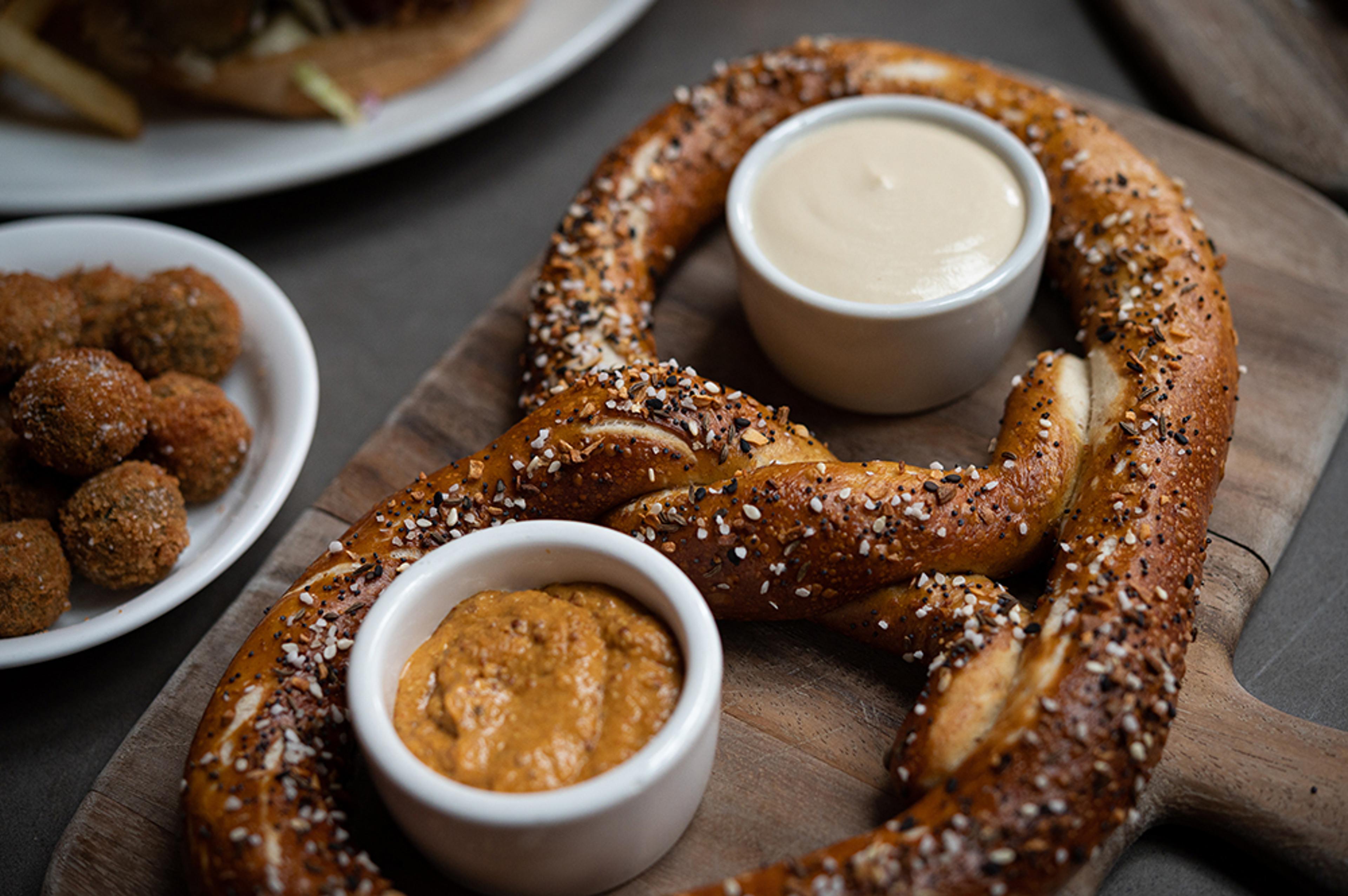 large pretzel with cheese sauce and house mustard