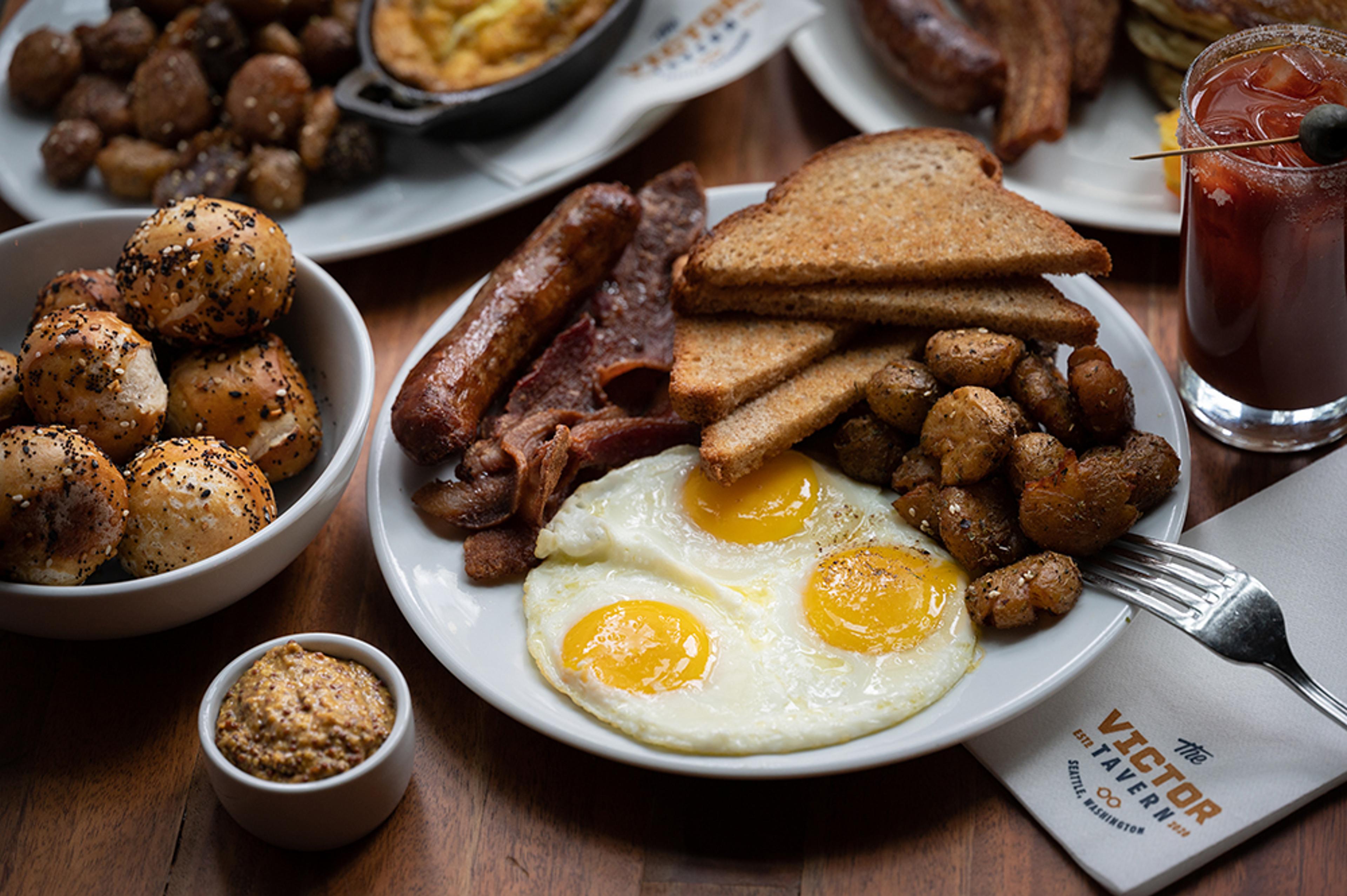 Eggs, bacon, sausage, potatoes and toast breakfast with Bloody Mary on side