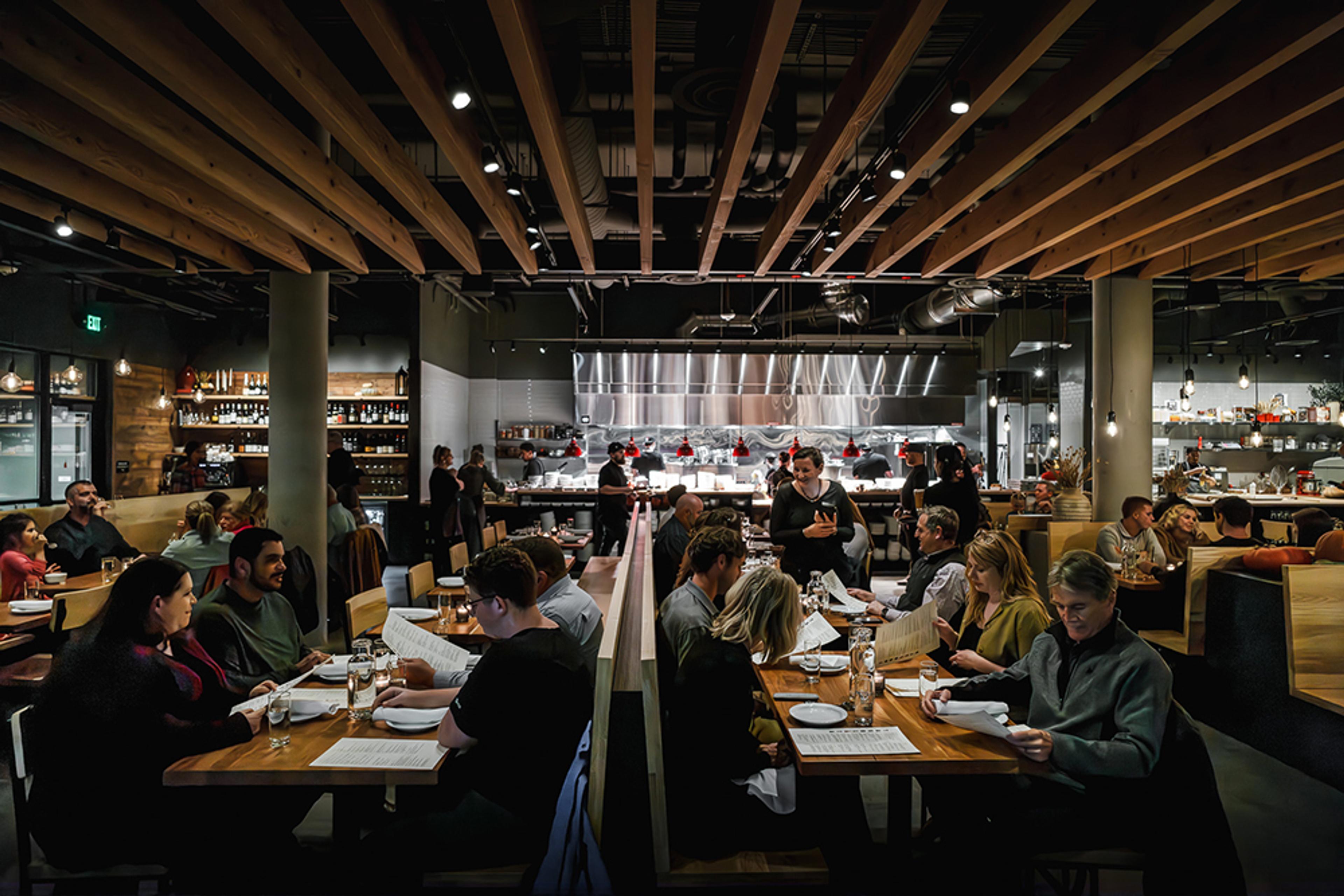 full dining room with server taking an order at table