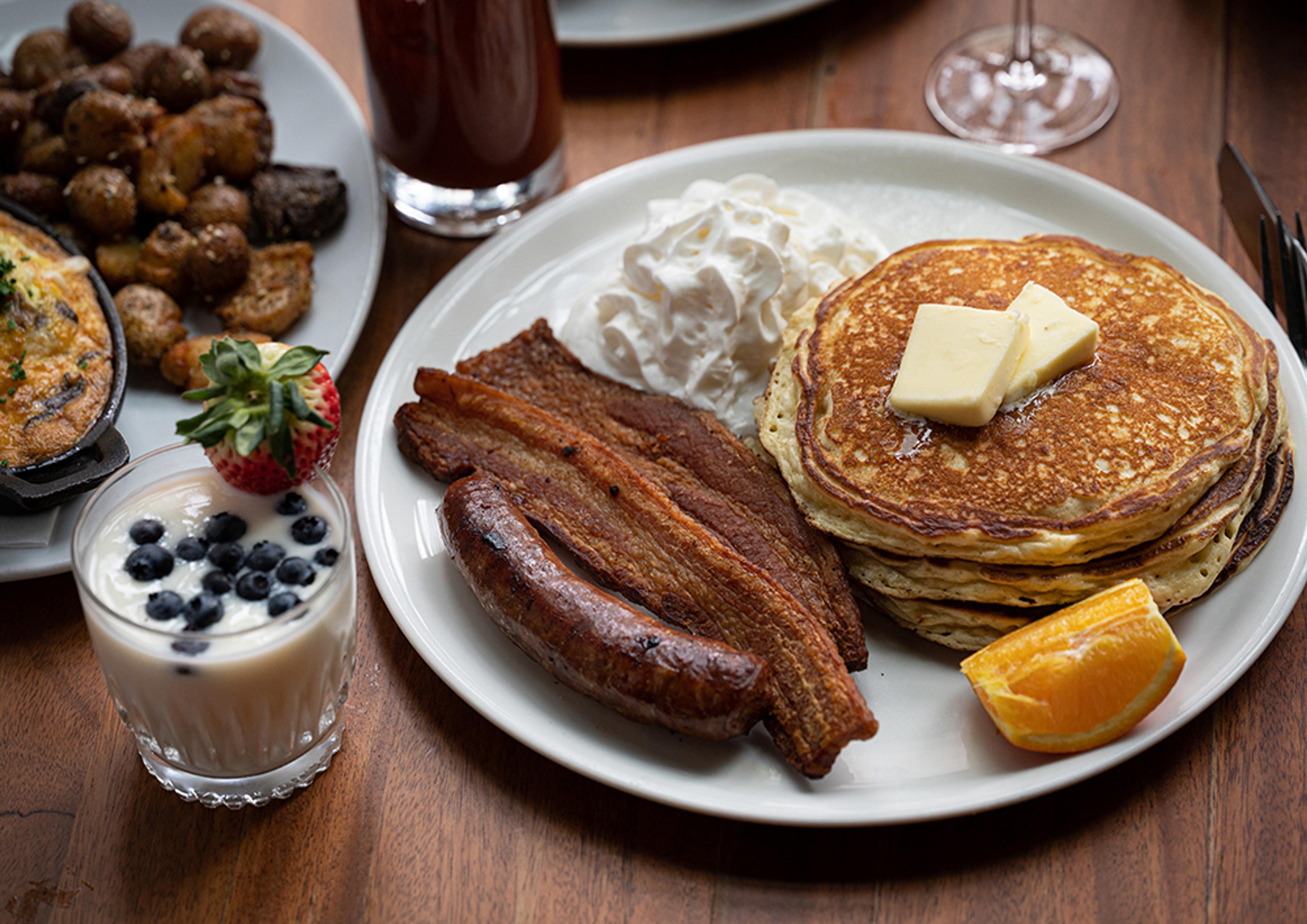 Brunch spread with pancakes, bacon, yogurt and Bloody Mary