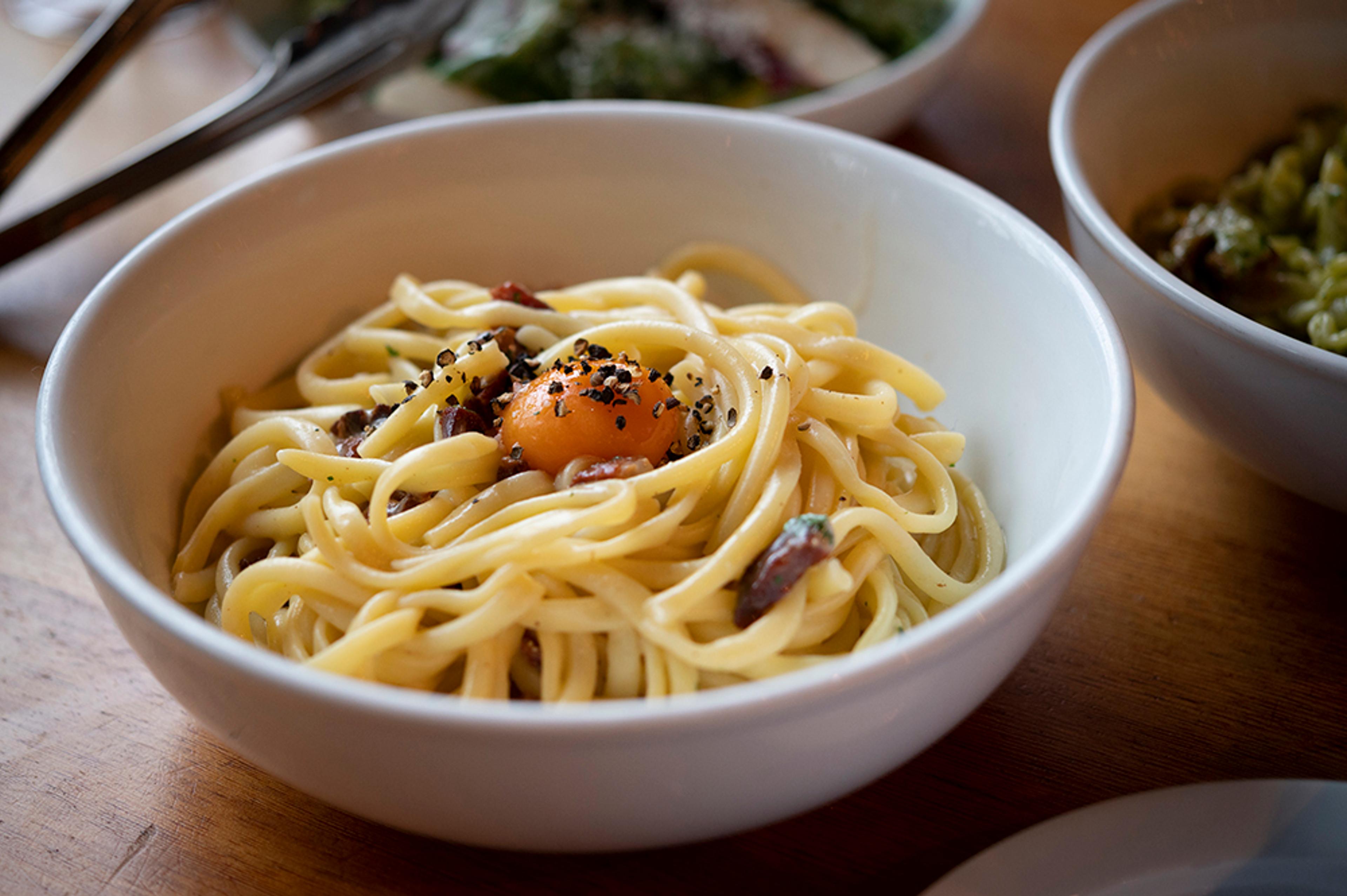 fresh pasta carbonara with egg yolk, black pepper, pancetta