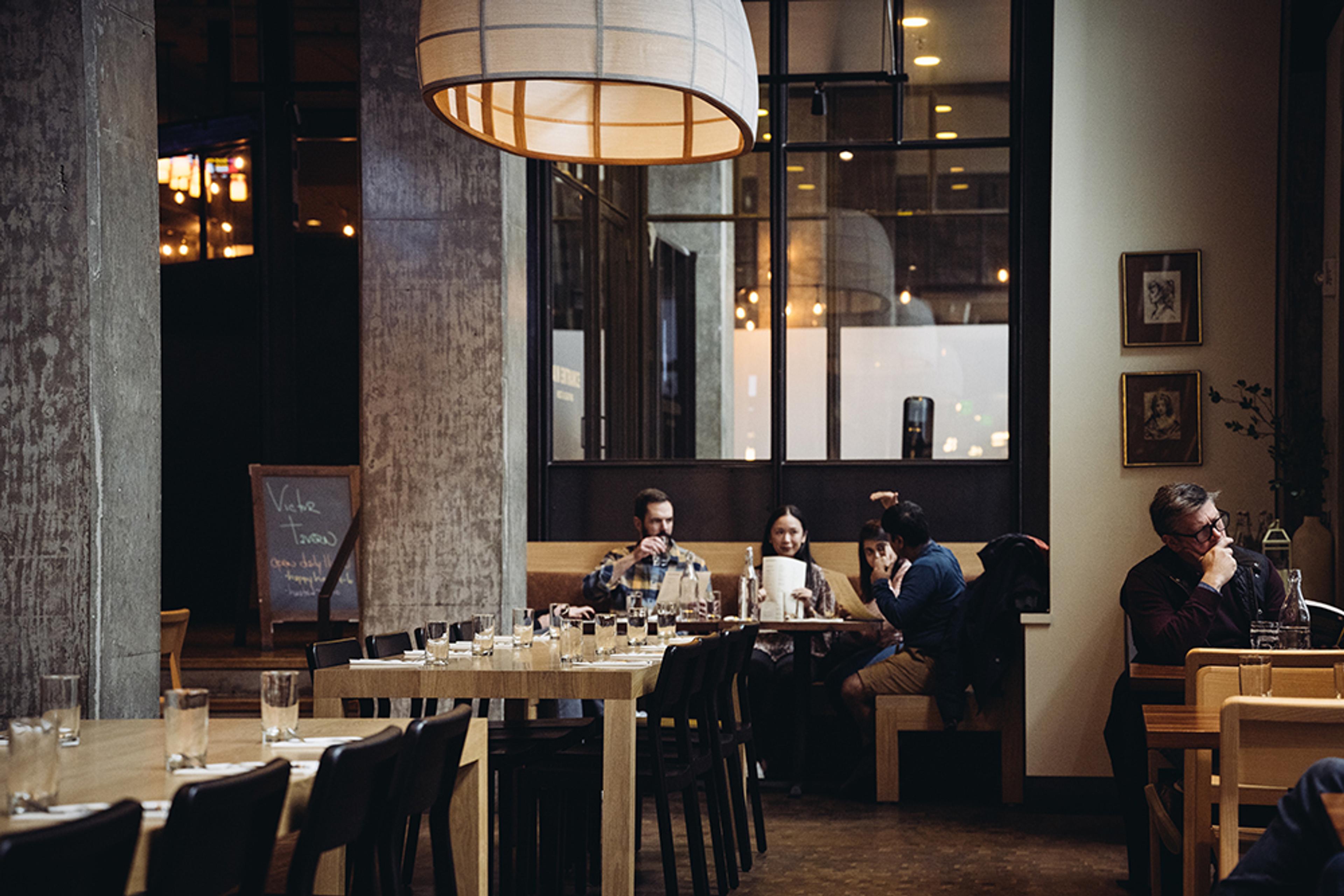 lively party at large booth table in high-ceiling dining room