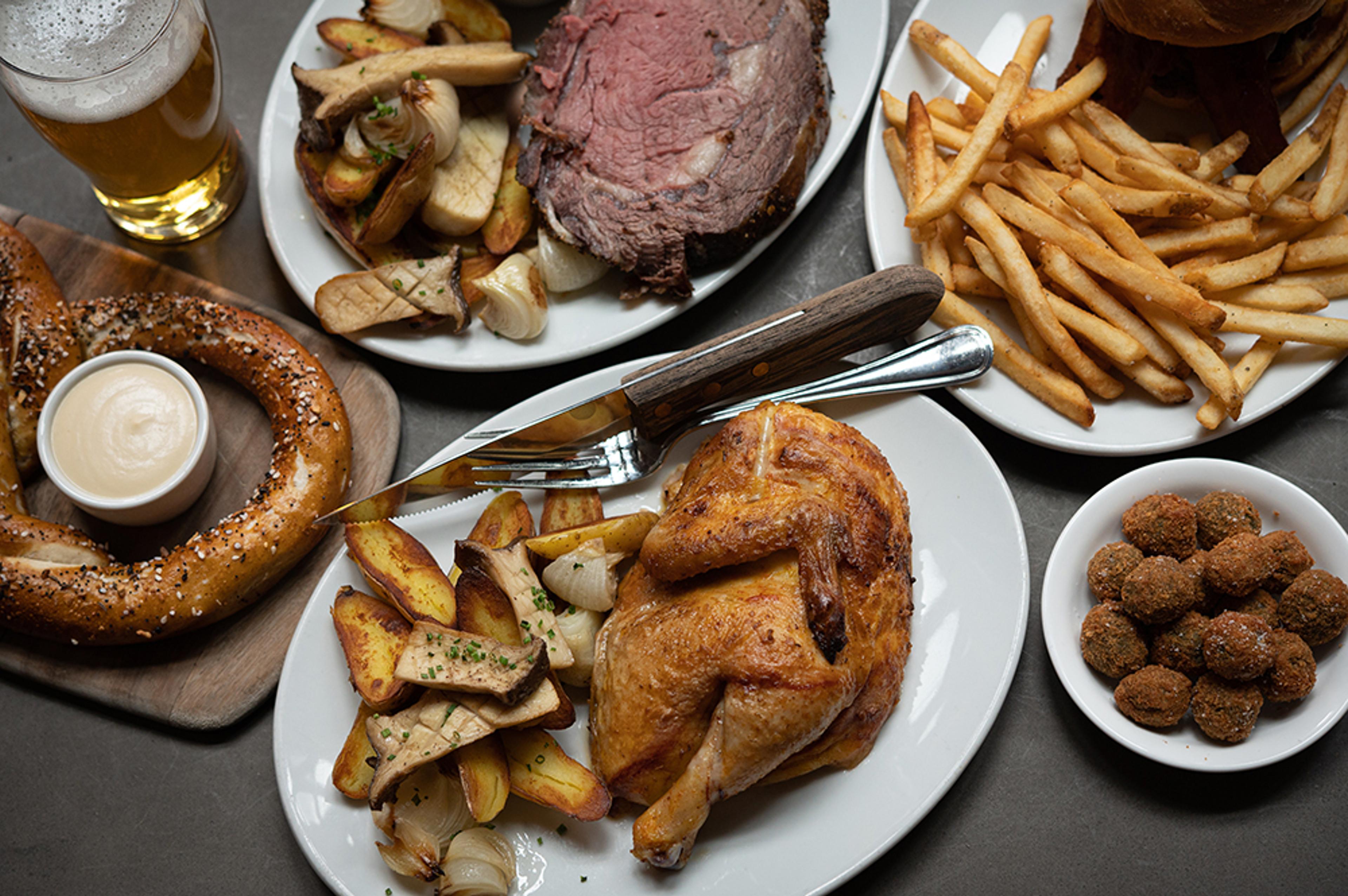 half rotisserie chicken alongside roasted mushrooms, potatoes, and prime rib