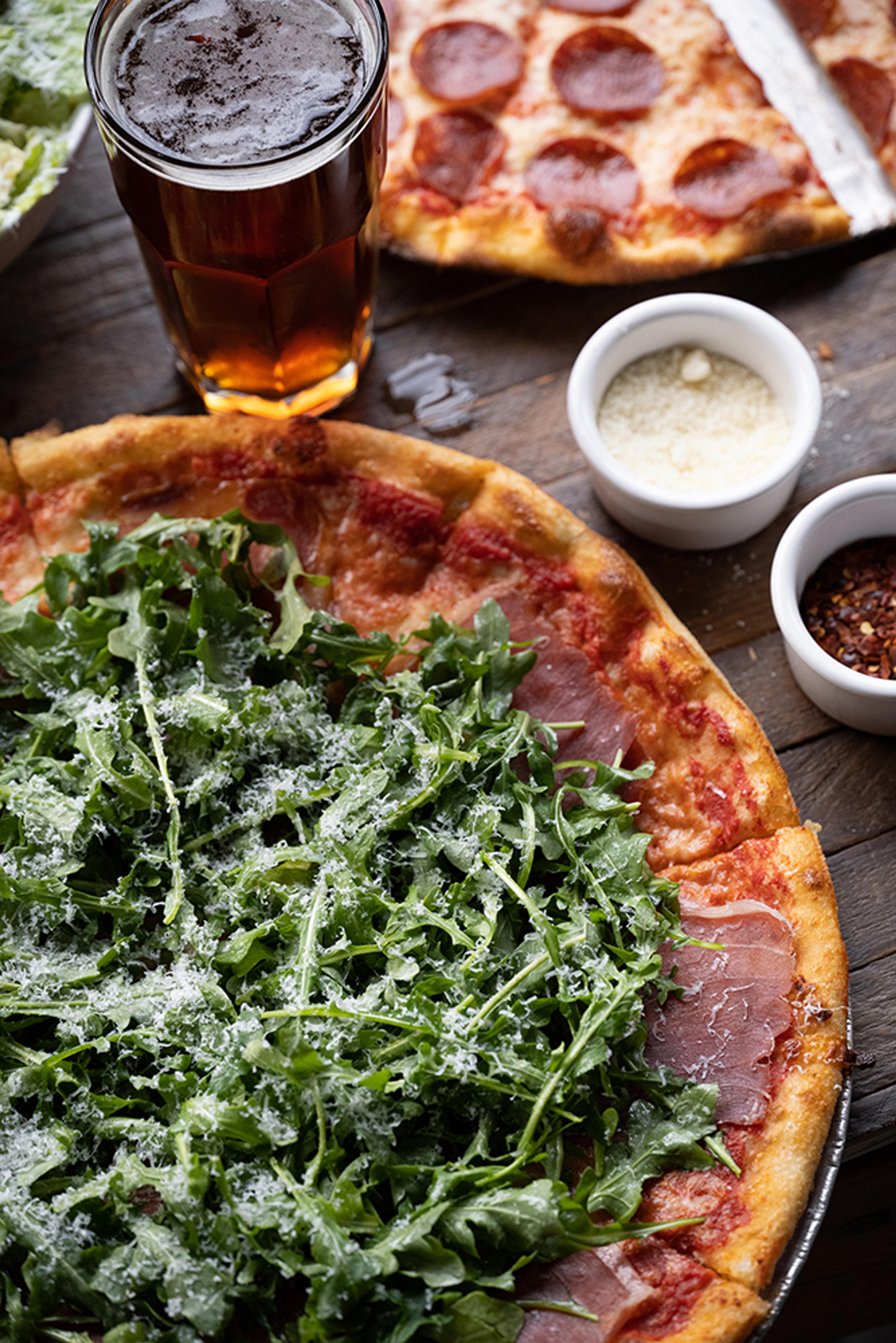 pizza topped with arugula and prosciutto