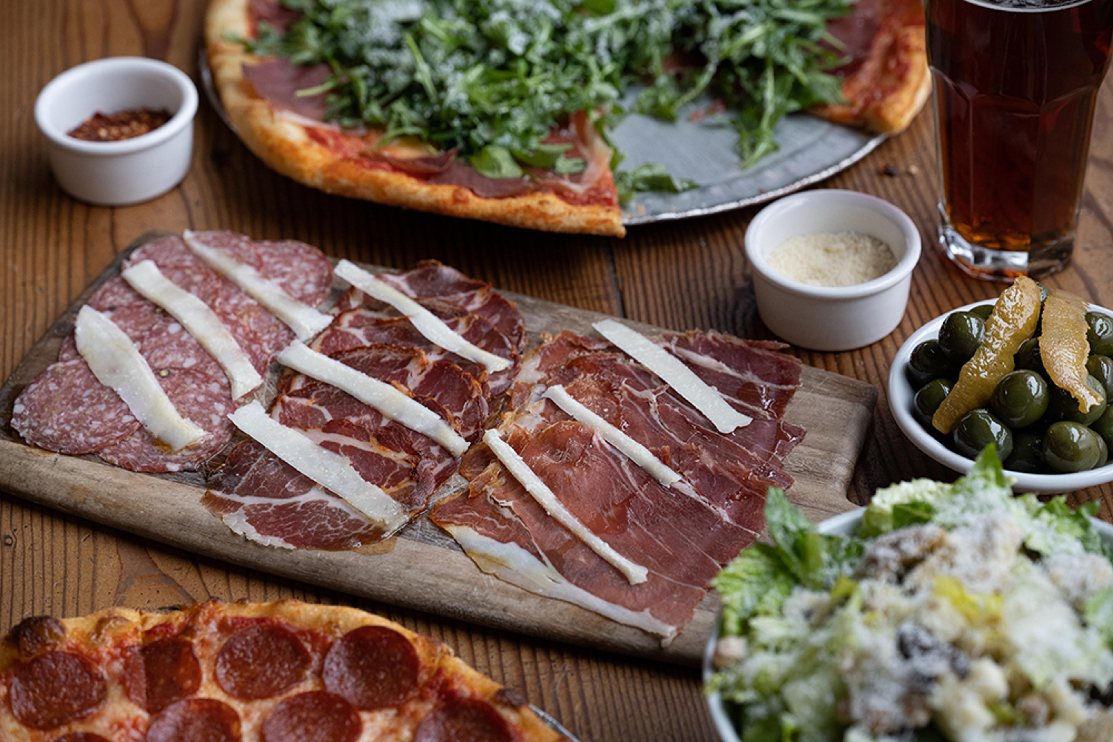 charcuterie board with pizza and olives