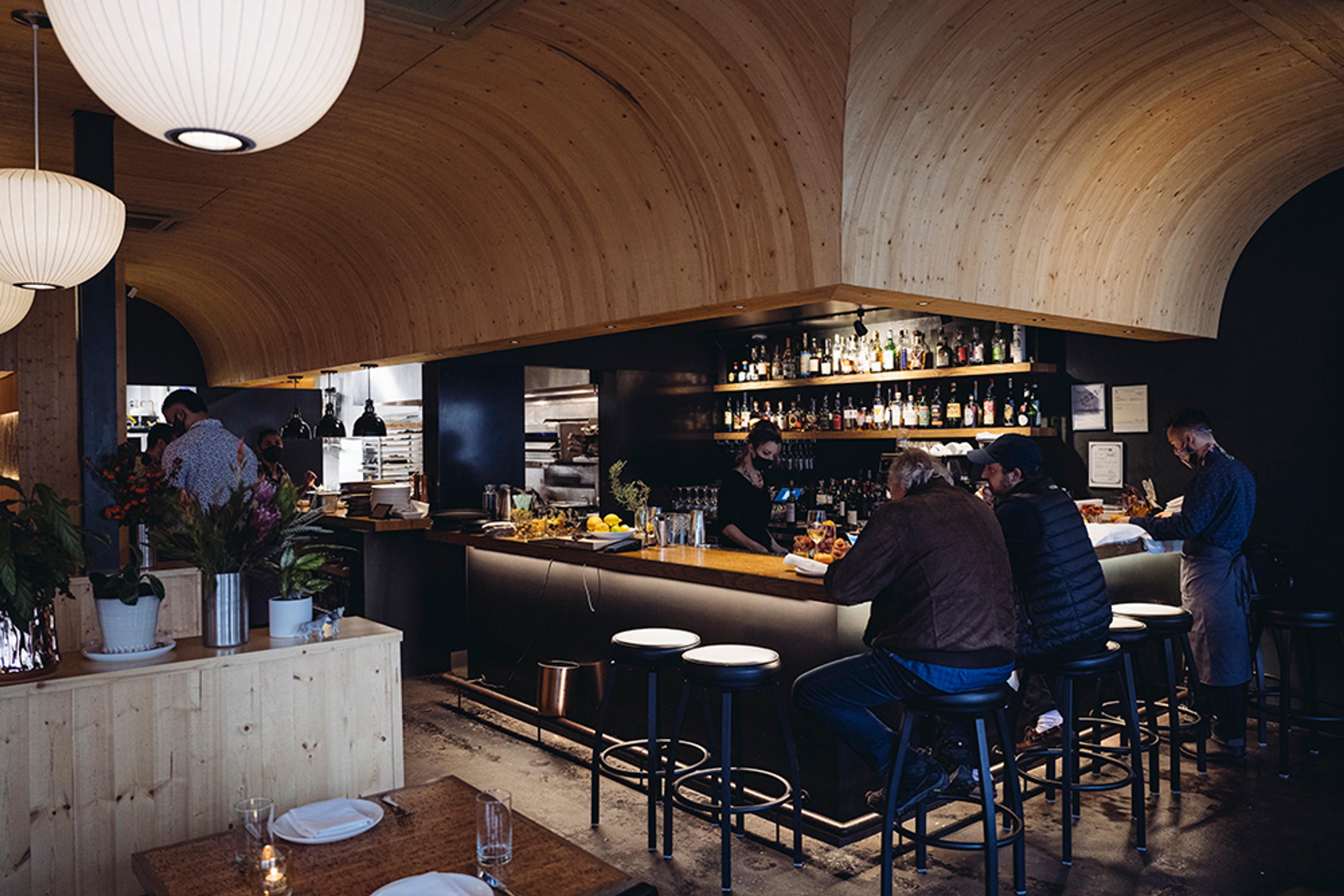 bar top over curved wood ceiling with patrons 
