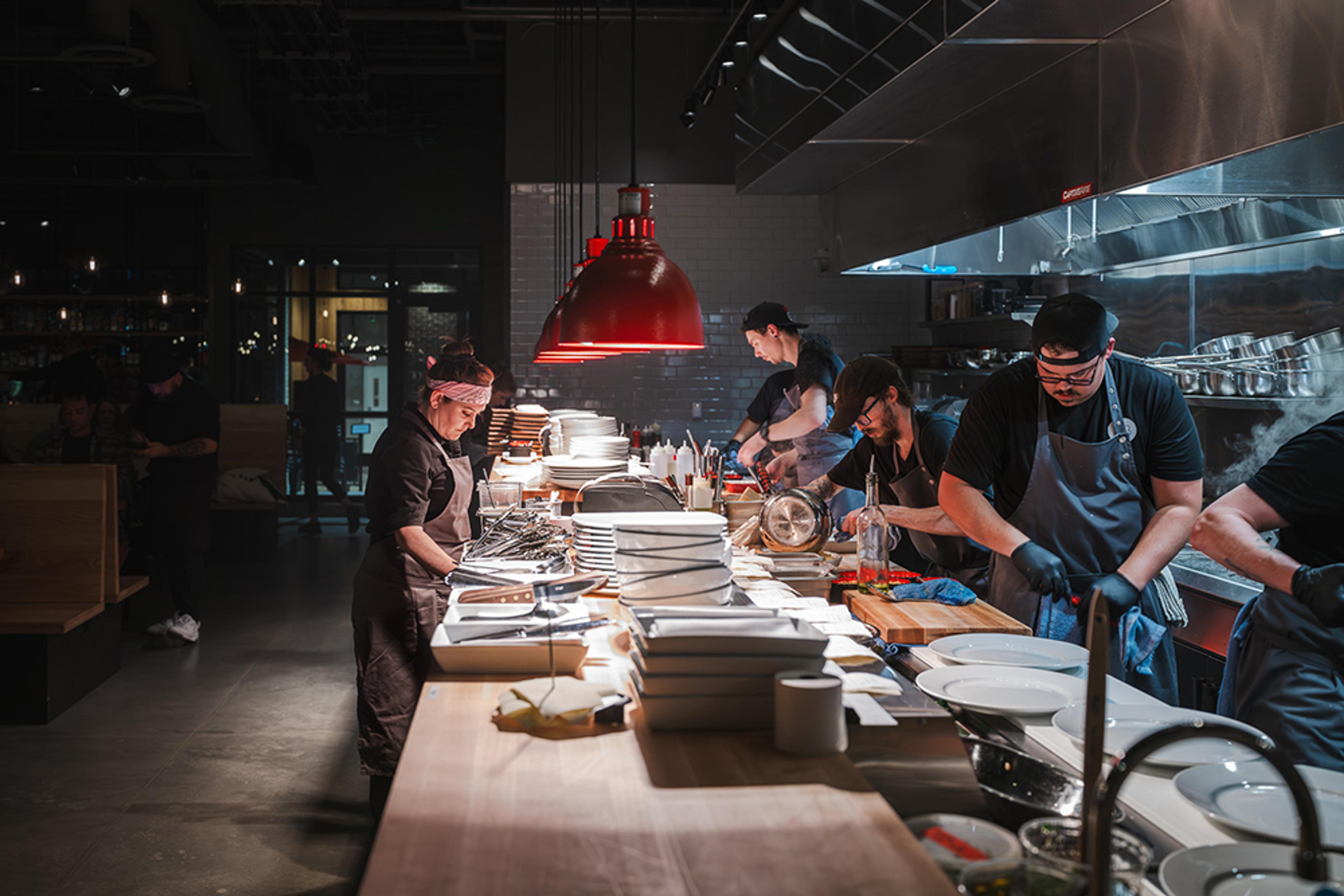 chef standing at counter while cooks are working