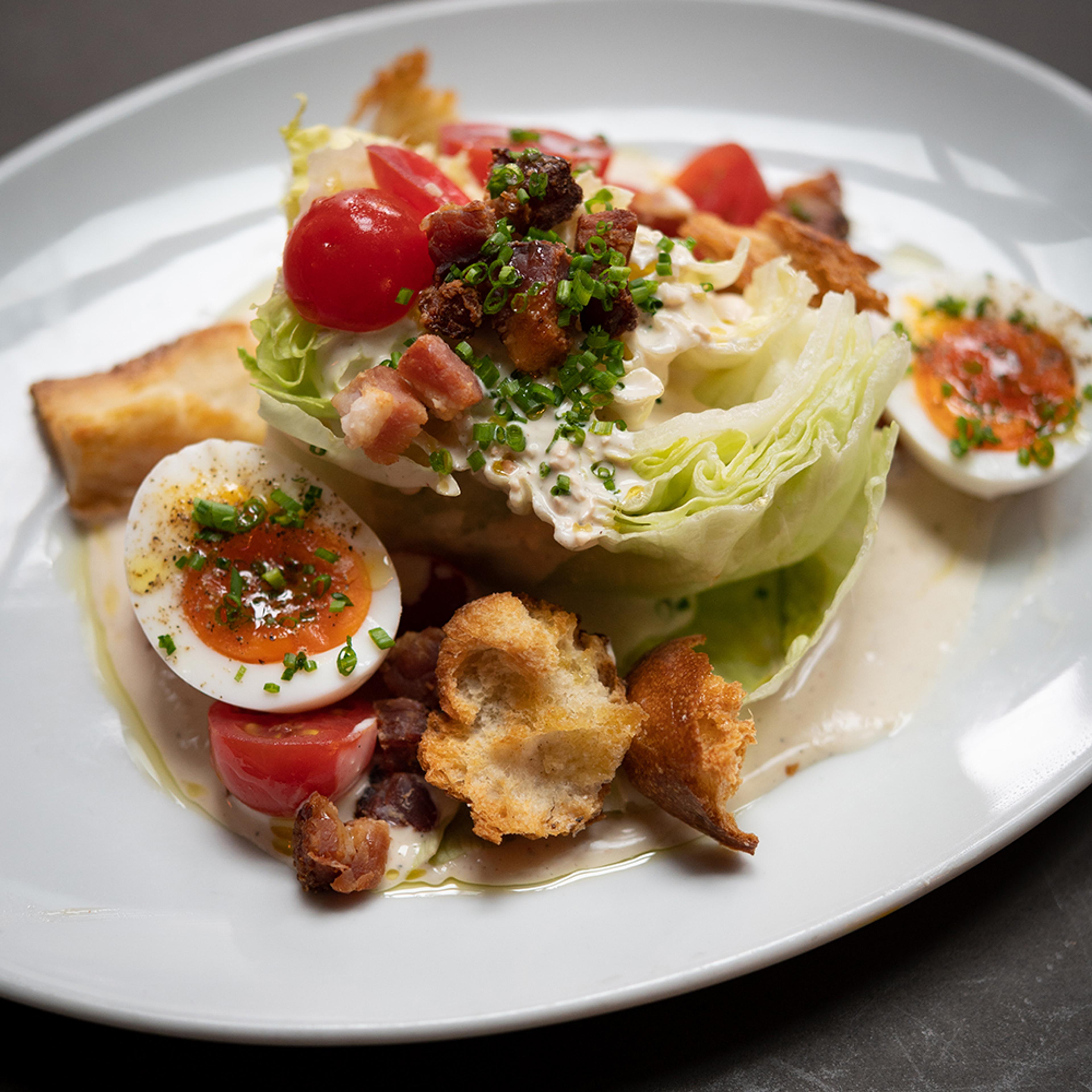 Wedge salad with soft boiled eggs, hand-torn croutons, bacon and cherry tomatoes