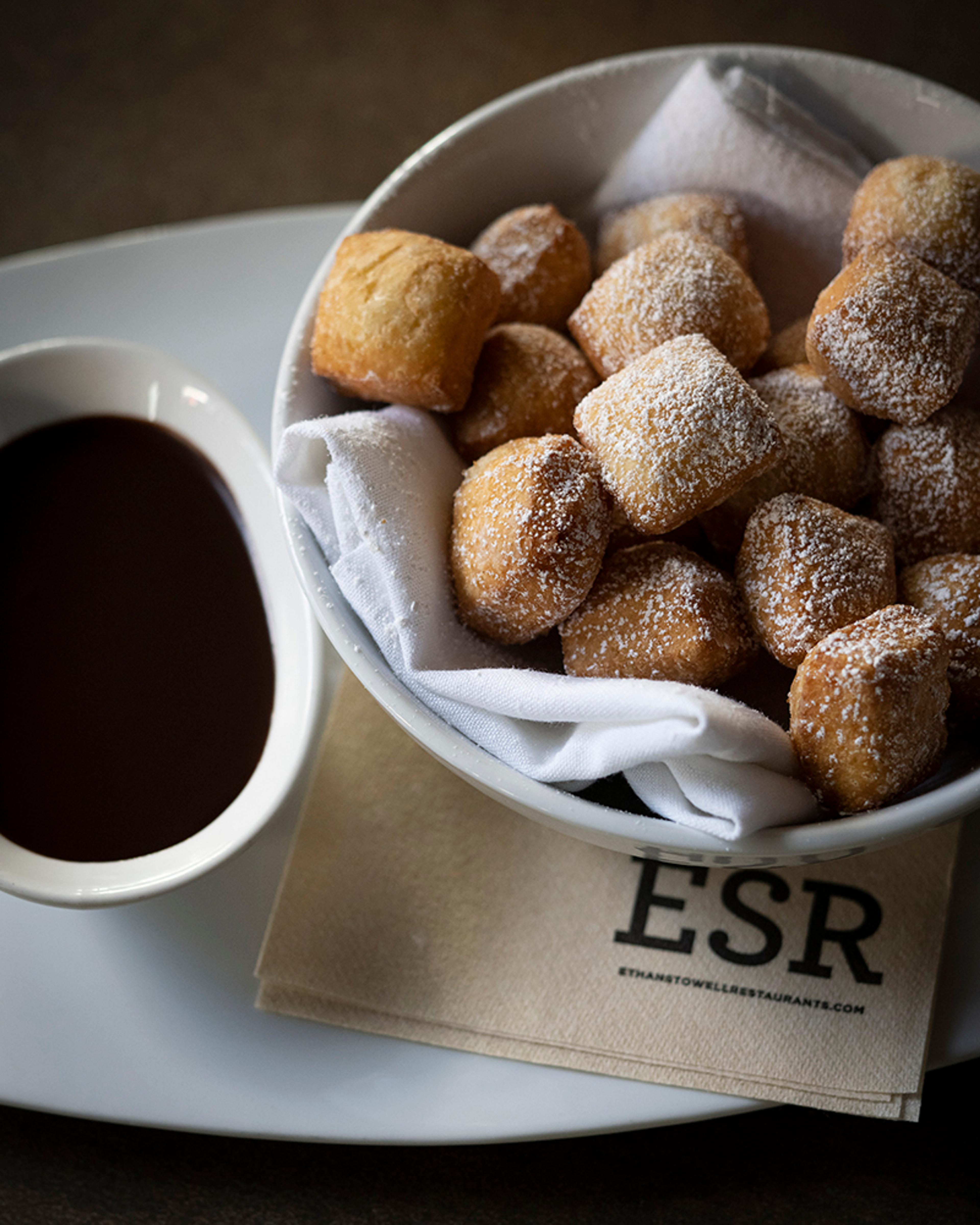 plate of zeppole with chocolate sauce for dipping