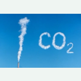 White smoke from a factory chimney forms “100 CO₂” against a blue sky
