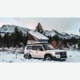 Hard-shell rooftop tent on a car in snow