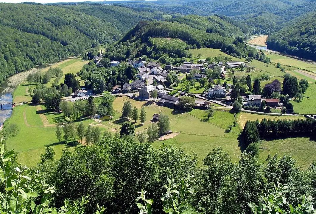 Veduta aerea di un piccolo paese circondato dalle colline boscose delle Ardenne