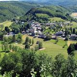 Veduta aerea di un piccolo paese circondato dalle colline boscose delle Ardenne
