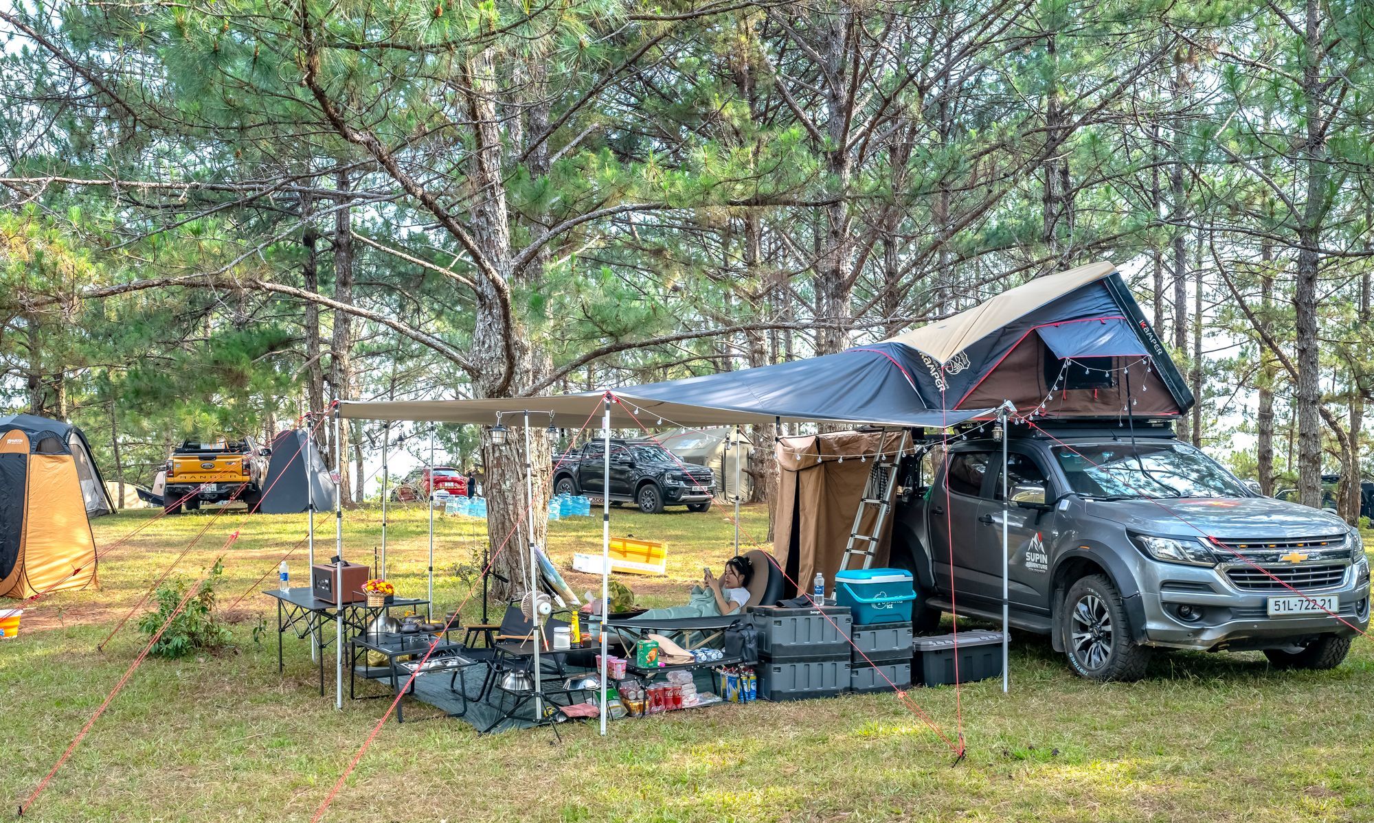 Campeggio completamente attrezzato con tenda da tetto tra gli alberi