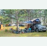 Fully equipped rooftop tent campsite among trees