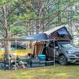 Campeggio completamente attrezzato con tenda da tetto tra gli alberi