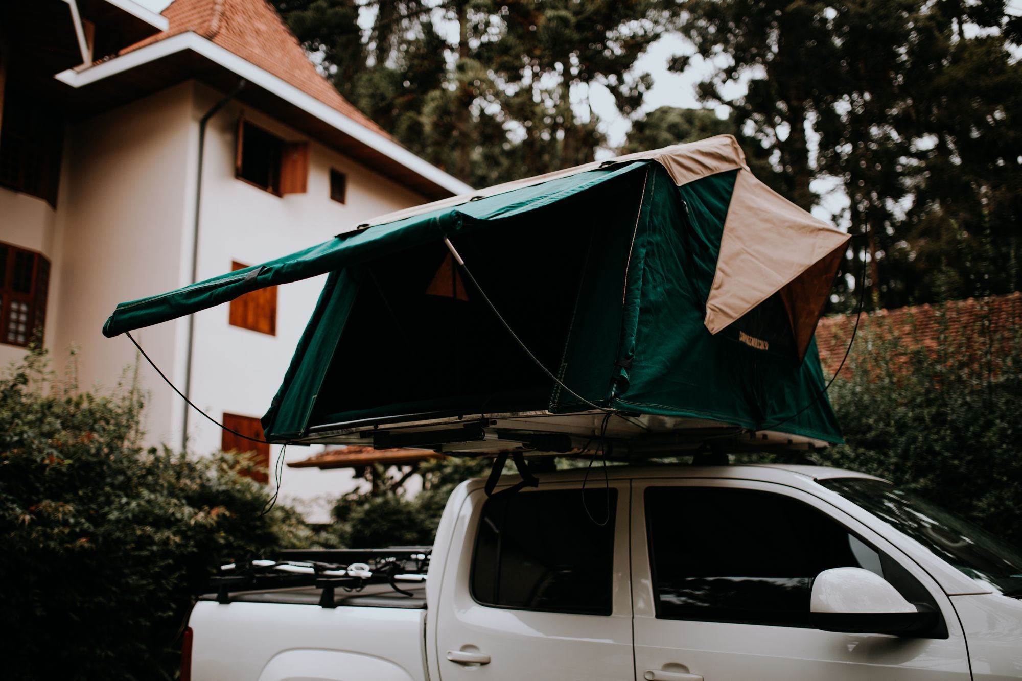 Tenda da tetto verde montata su un pick-up bianco