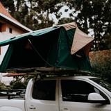 Tenda da tetto verde montata su un pick-up bianco
