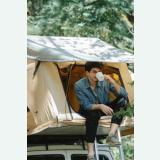 Camper drinking a hot drink inside a tent