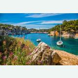 Sailboats anchored in a turquoise rocky cove in the south of France