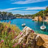 Barche a vela ancorate in una cala rocciosa dalle acque turchesi nel sud della Francia