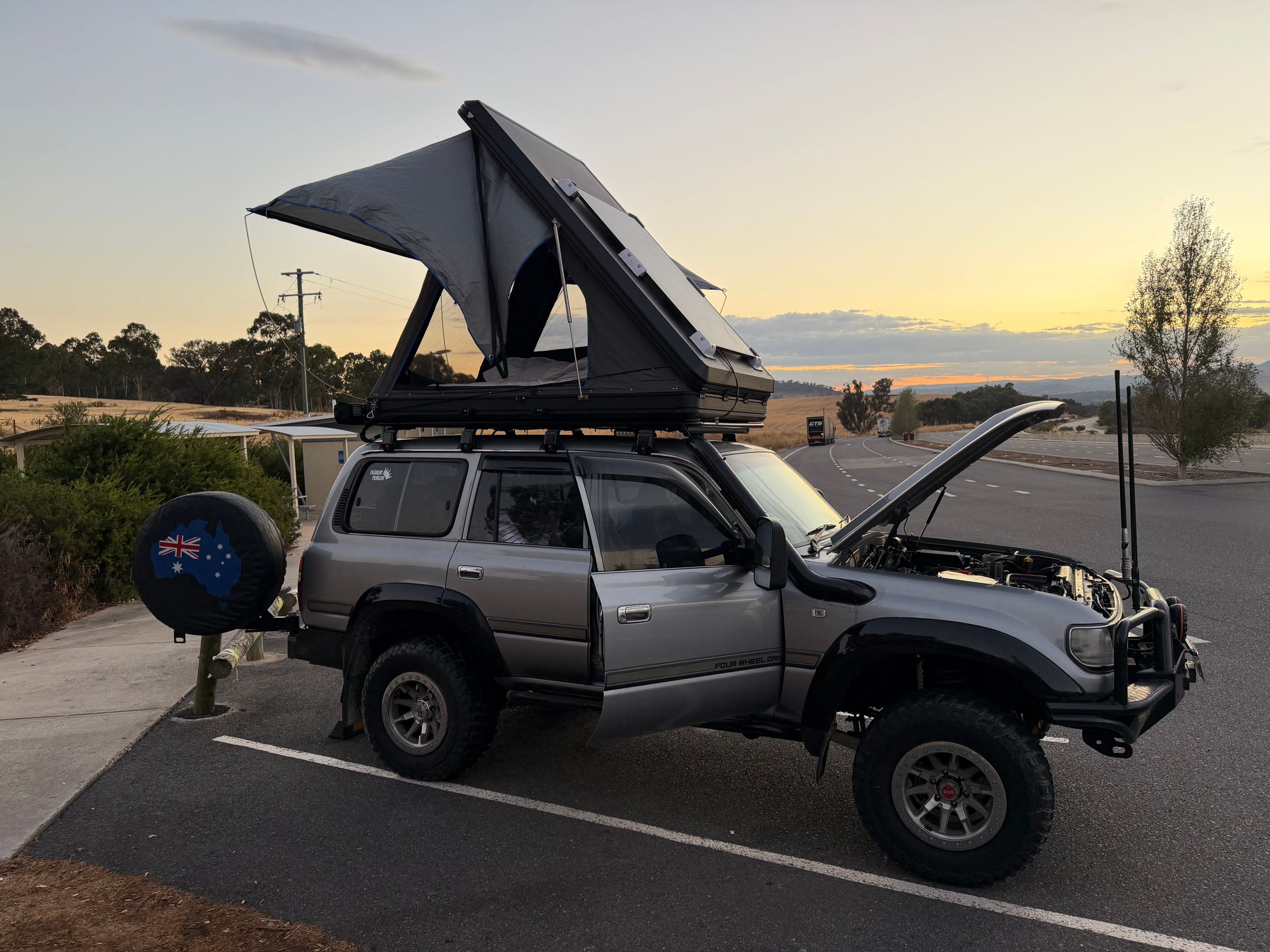 Tenda da tetto rigida aperta su un fuoristrada al tramonto