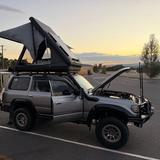 Tenda da tetto rigida aperta su un fuoristrada al tramonto