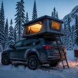 Tenda da tetto isolata e illuminata su un SUV in una foresta innevata