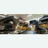 Several rooftop tents displayed on vehicles inside a Brussels showroom