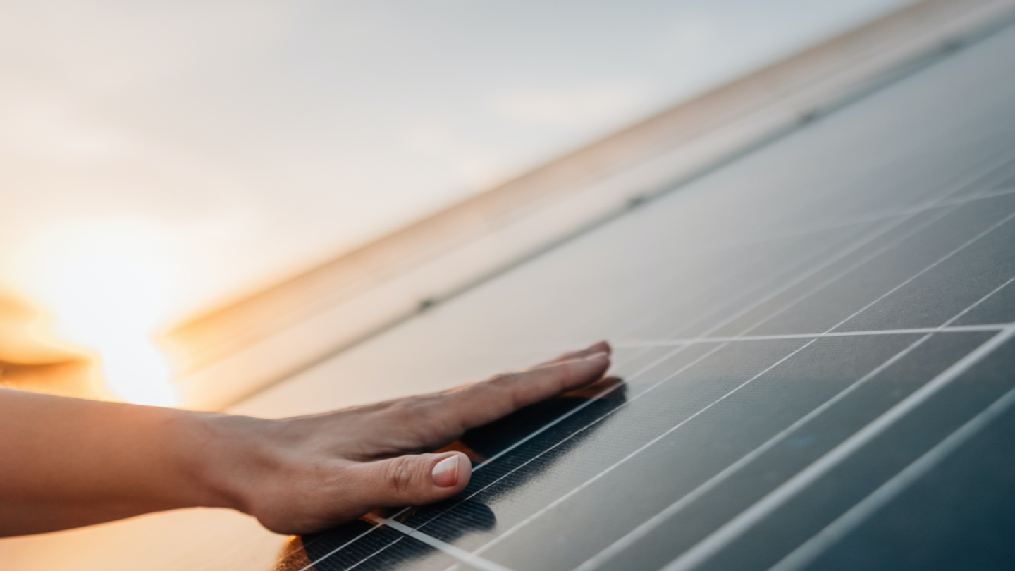 Hand touching a solar panel