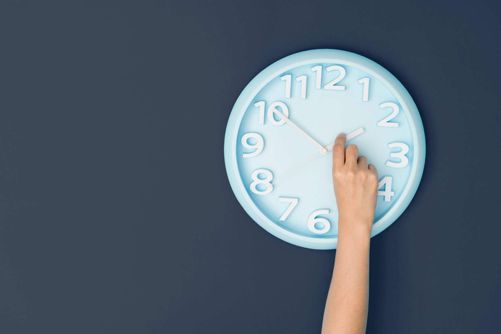 Hand turning the clock back