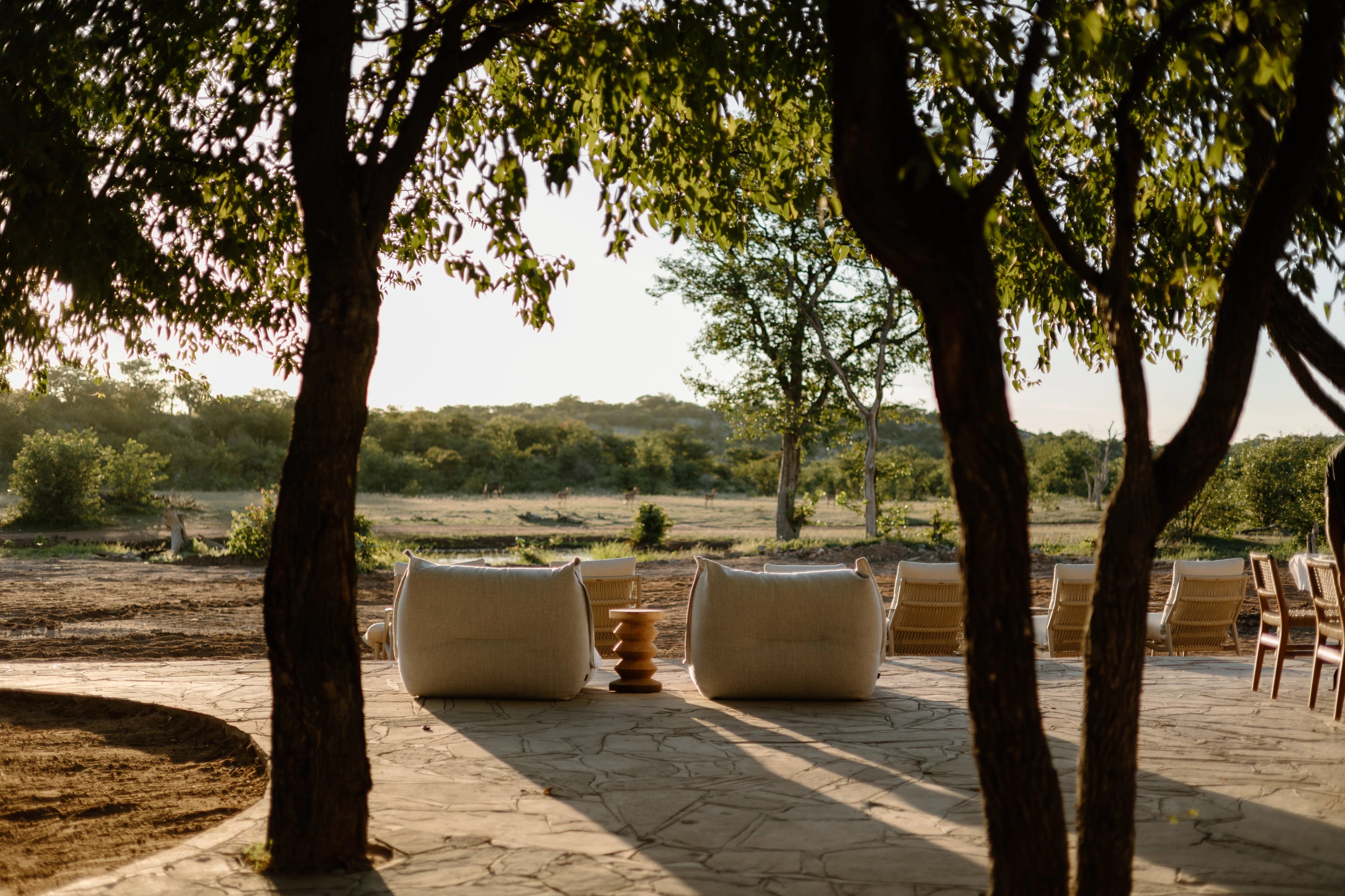 Comfortable, contemporary seating overlooking the waterhole at Encounter — a tranquil space where guests can unwind as wildlife gathers just beyond the deck, and every moment feels quietly connected to the rhythms of the wild.