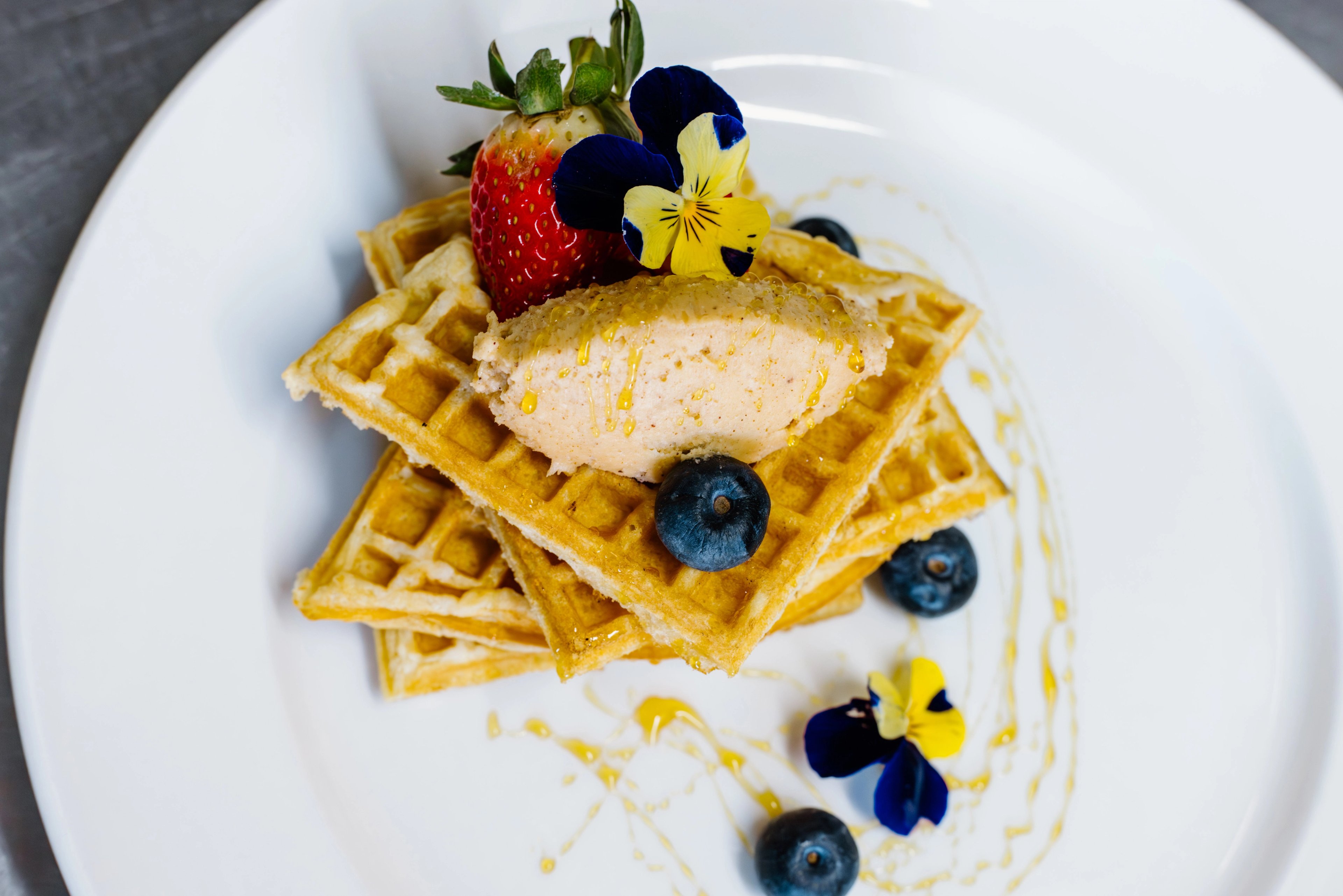 A golden waffle stack layered with chorizo crumble and crowned with an Amarula butter. A dish that is playful, bold, and distinctly African.