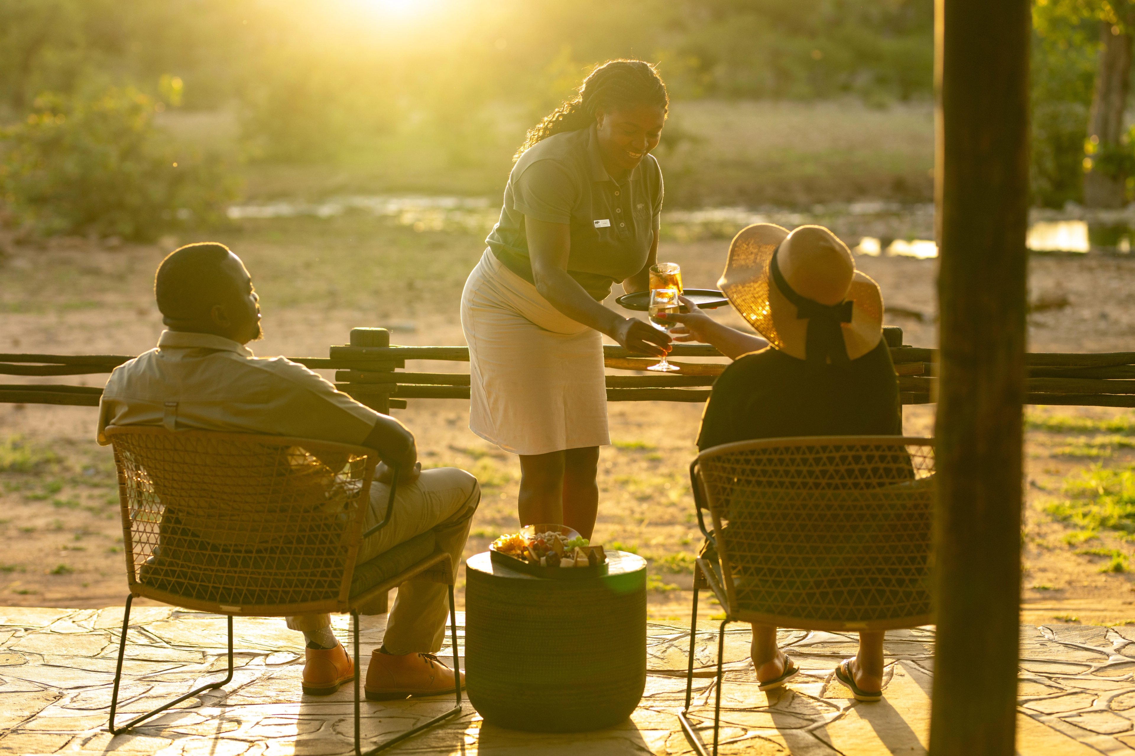 Time slows on the main deck as guests settle in, taking in the view of the waterhole while being served drinks, where quiet comfort allows the landscape to take centre stage at Tented Camp.