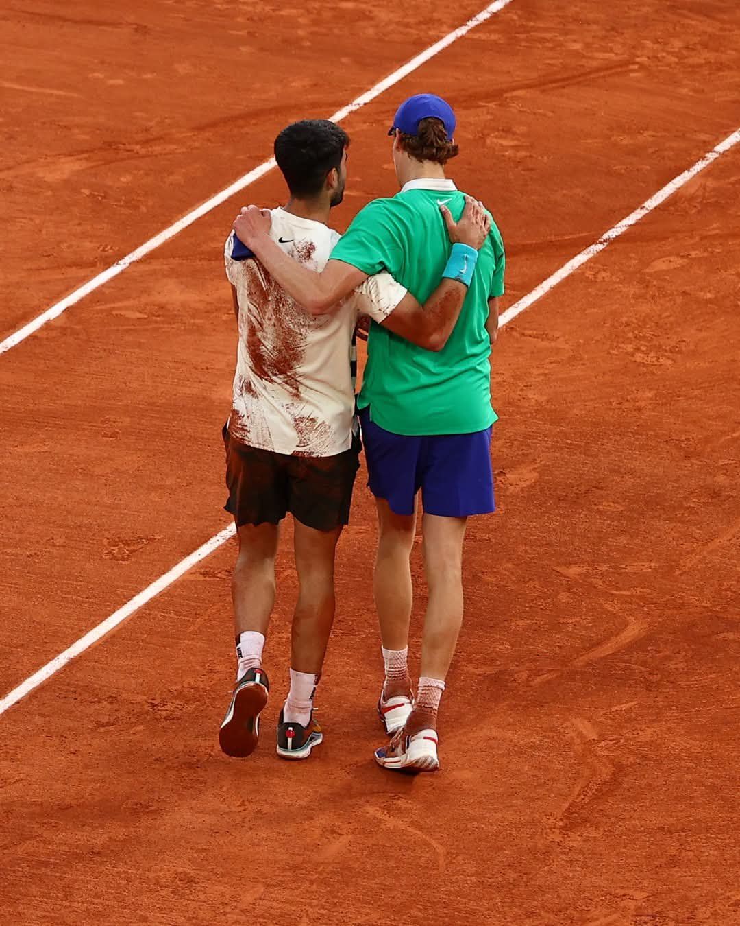 Jannik Sinner e Carlos Alcaraz camminano insieme dopo la finale