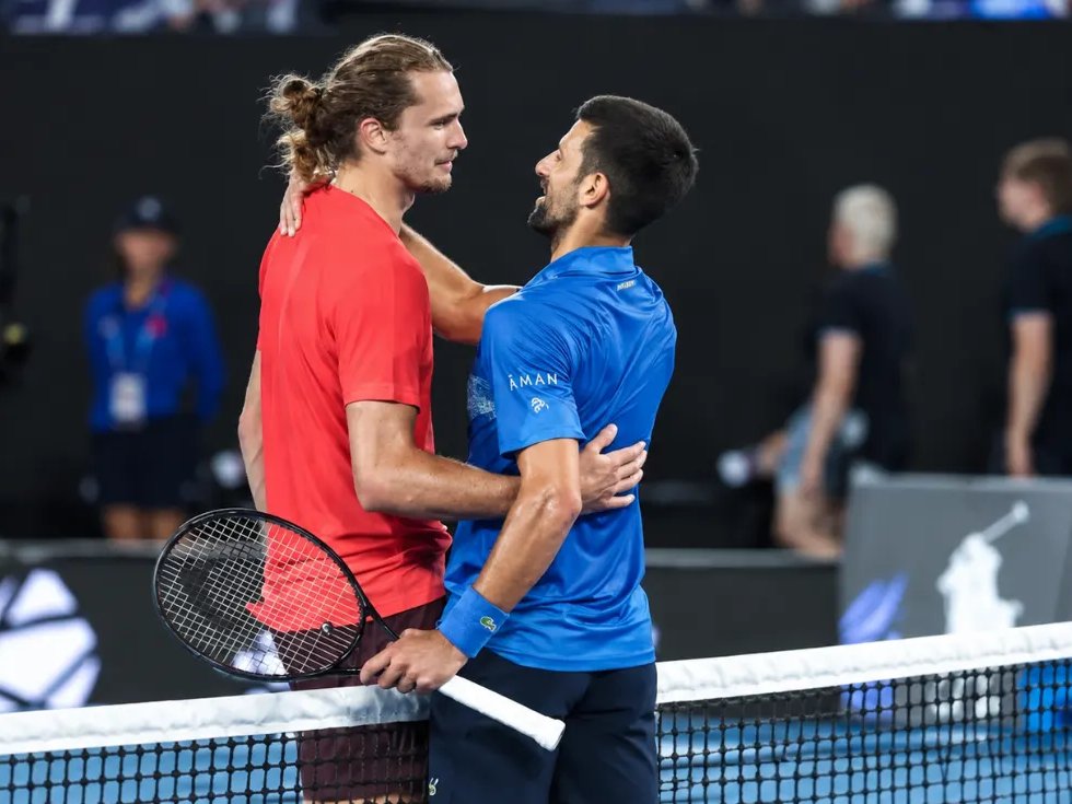 Zverev und Djokovic umarmen sich am Netz am Ende eines Matches